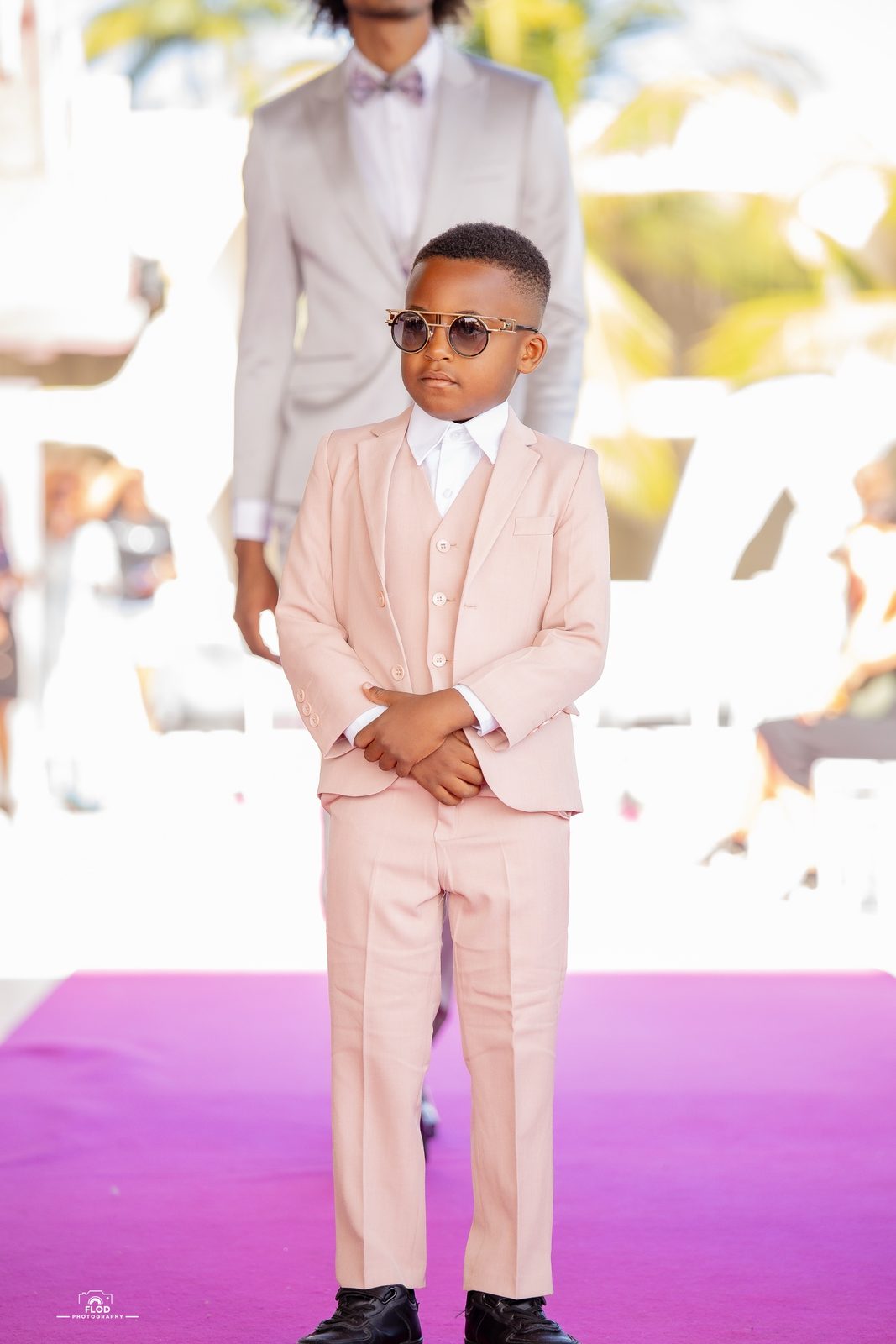 Défilé mode enfant, costume rose et lunettes rondes sur le podium
