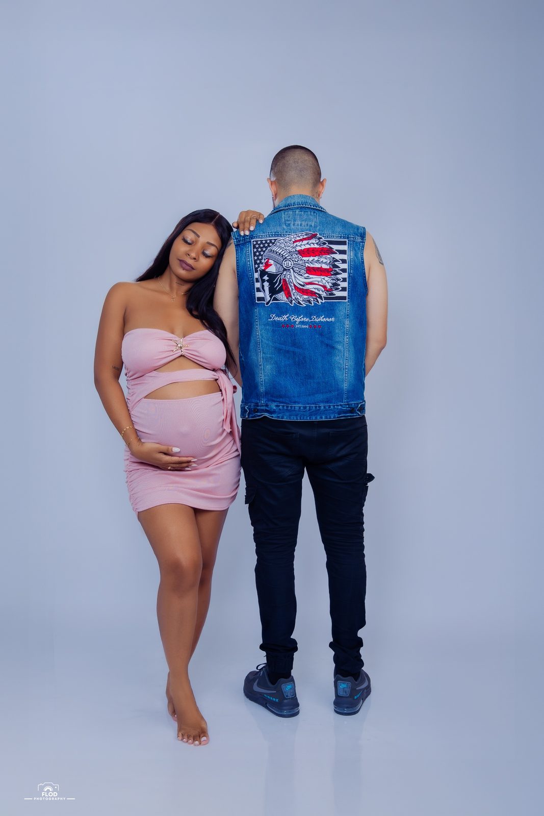 Séance grossesse en couple en studio, future maman en rose et futur papa de dos