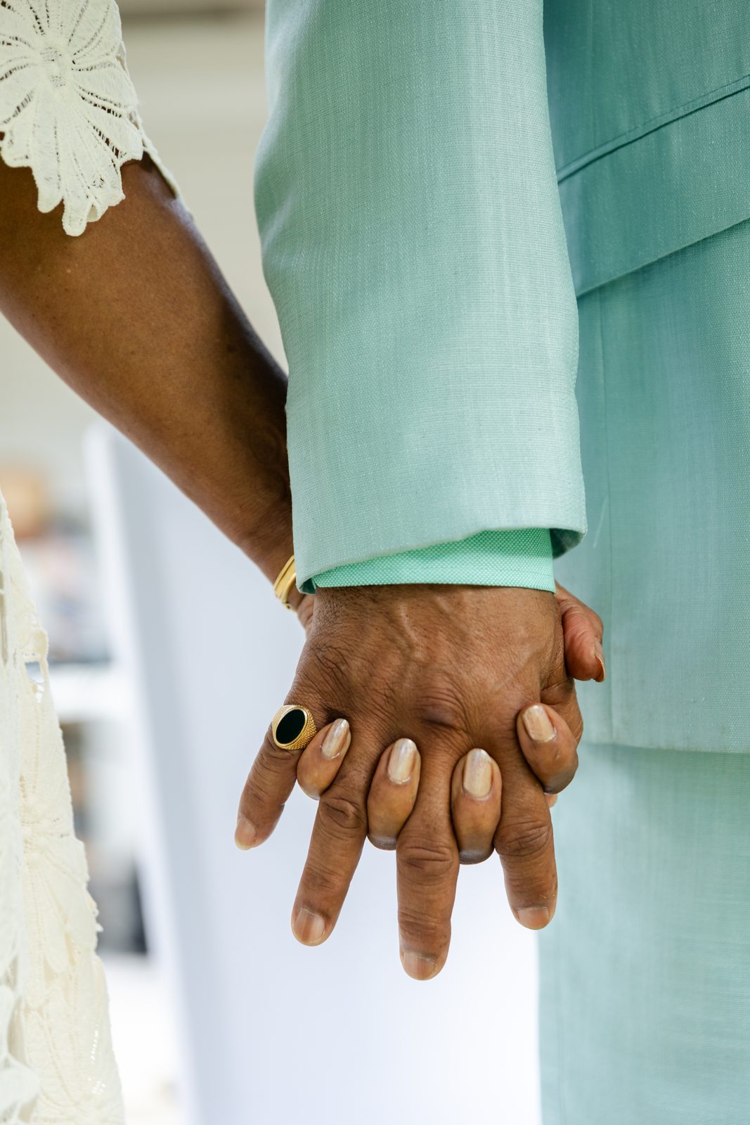 Mains enlacées des mariés, chevalière en or, mariage civil en Guadeloupe