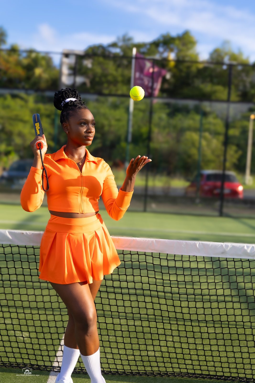 Portrait sport sur un court de padel, lancer de balle en tenue orange