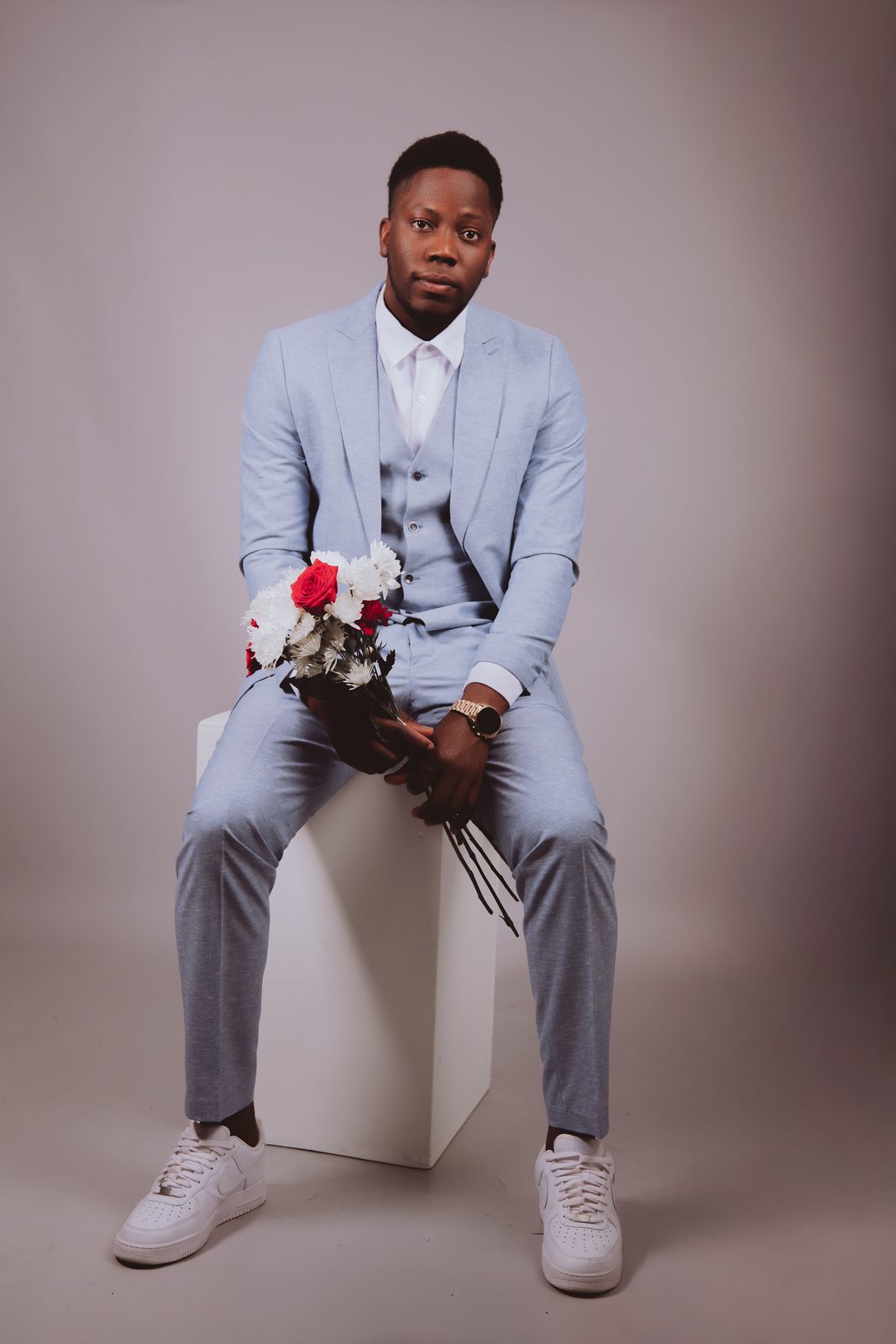 Portrait du futur marié en costume bleu clair avec bouquet, séance pré-wedding