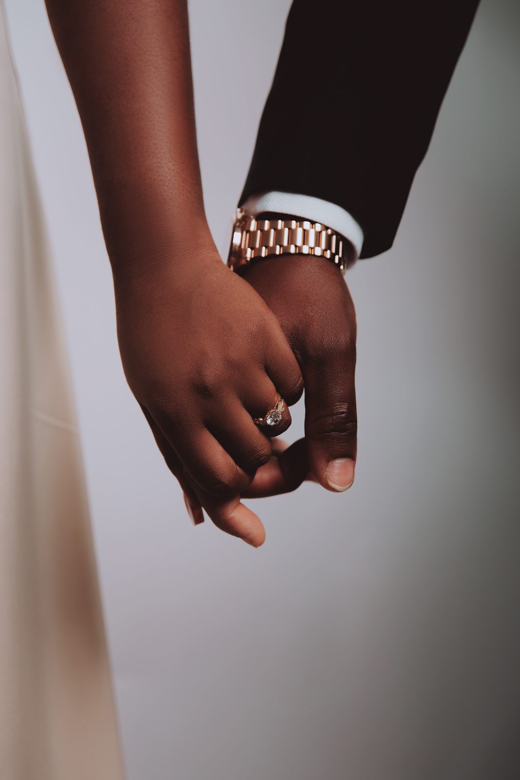 Mains des fiancés enlacées, gros plan sur la bague de fiançailles