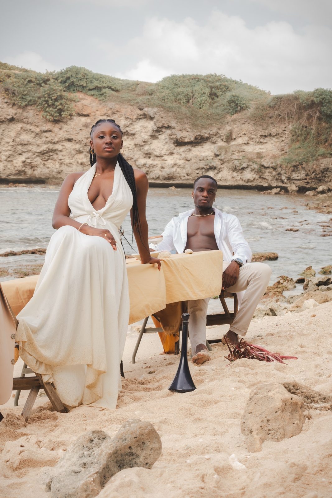 Couple attablé sur le sable, mise en scène dîner à la plage